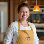 Portrait of Chloe Davis, Culinary Workshop Instructor, smiling and holding a rolling pin.